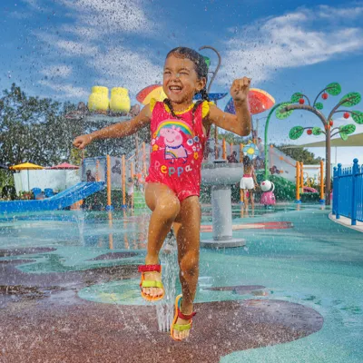 Peppa Pig Park Matschepfützen Wasserspielplatz Mädchen springt durchs Wasser